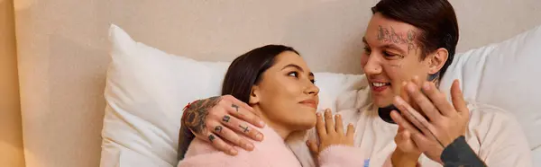 Un couple se blottit sur un lit doux, échangeant regards aimants et rires, embrassant leur lien. — Photo de stock