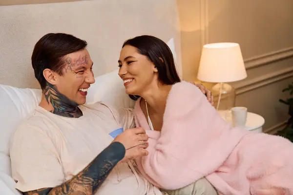 A young couple shares laughter and affection on a blissful evening in their cozy space. — Stock Photo