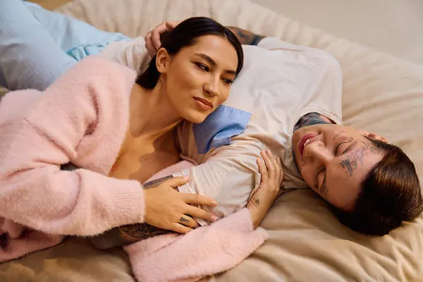 A young couple cuddles closely, sharing smiles and warmth in a relaxing indoor setting. — Stock Photo