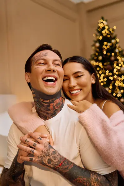Una coppia felice gode di un abbraccio amorevole, circondata da decorazioni festive e spirito natalizio. — Foto stock