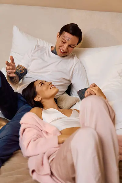 Un couple amoureux partage le rire et la joie tout en se prélassant confortablement dans un espace détendu. — Photo de stock