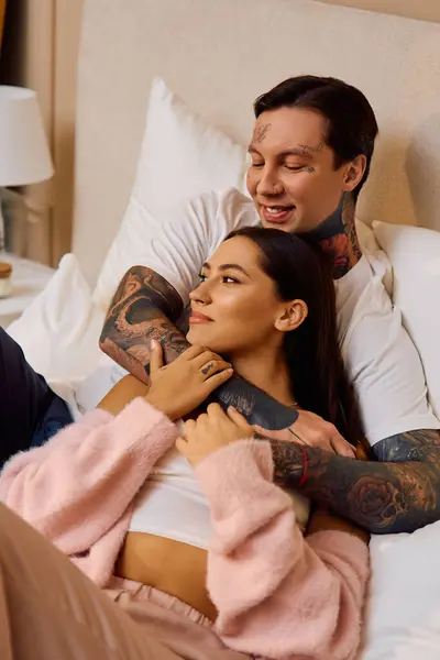Young couple embraces tenderly on a bed, exchanging smiles and joy in their intimate space. — Stock Photo