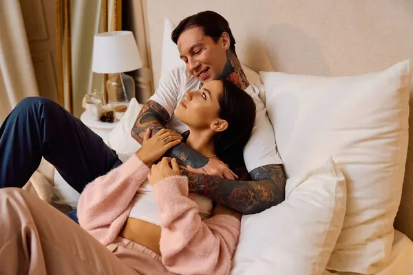 A man and woman enjoy an affectionate moment on a comfortable bed in a serene setting. — Stock Photo