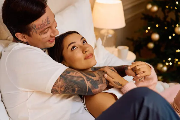 Loving couple enjoys each others company while relaxing in a festive, warmly lit space. — Stock Photo