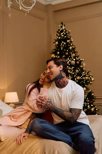Couple jouit de l'autre embrasser sur un lit décoré pour la saison des fêtes, rayonnant d'amour. — Photo de stock