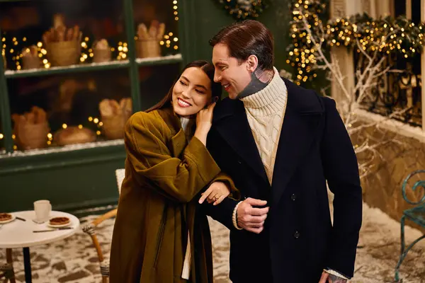 A loving couple enjoys each others company in a charming winter cafe decorated for the season. — Stock Photo