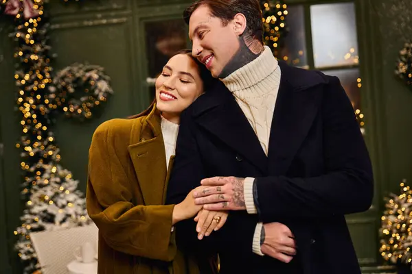 Young couple enjoys a cozy moment together surrounded by twinkling lights and plants. — Stock Photo