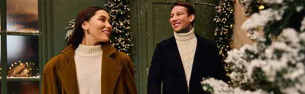 A loving couple walks together, smiling and sharing joy in a winter wonderland setting. — Stock Photo
