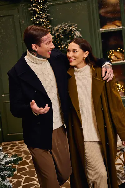 Loving couple shares joyful laughter while embracing in a festive holiday setting. — Stock Photo