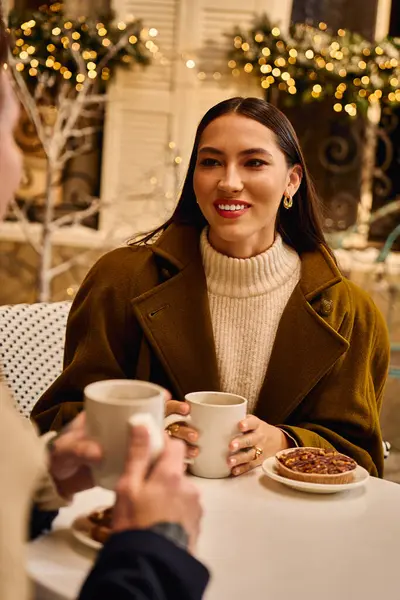 Casal amoroso compartilha sorrisos e calor enquanto bebe bebidas em uma atmosfera festiva café. — Fotografia de Stock