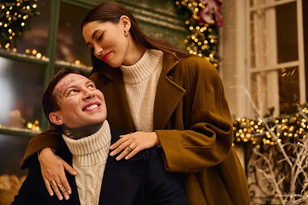 A joyful couple enjoys each others company in a beautifully decorated winter space. — Stock Photo