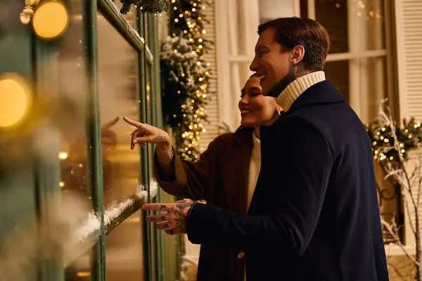 Couple enjoys time together, admiring beautiful holiday decorations in a charming spot. — Stock Photo