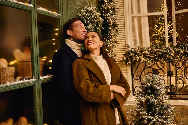 A young couple shares a tender moment while enjoying the holiday spirit outdoors. — Stock Photo