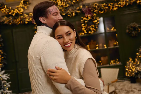 Young lovers joyfully celebrate together amid twinkling lights and holiday cheer. — Stock Photo