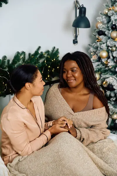 Loving couple enjoys each other under festive lights during the holiday season — Stock Photo