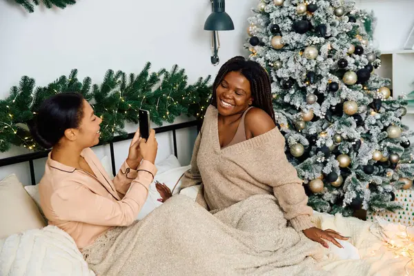 Warm laughter and joy as two women share a sweet moment while celebrating the holidays together. — Stock Photo