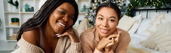 Two women smile brightly while enjoying a warm moment together in a festive atmosphere. — Stock Photo
