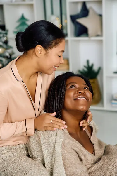 Two women share laughter and warmth while enjoying quality time in their stylish living space. — Stock Photo