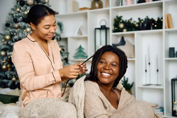 Two women connect in a warm, cozy living room, sharing laughter and love during a winter evening. — Stock Photo