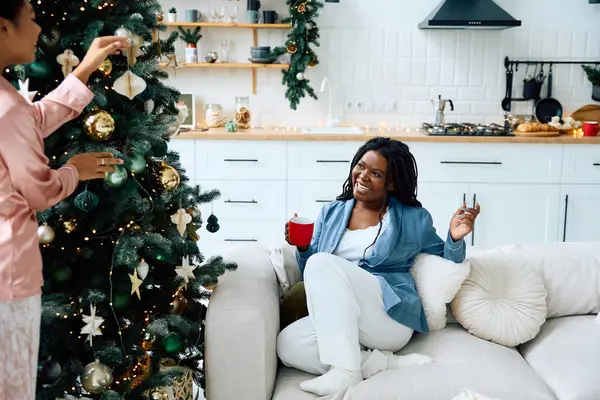 Una coppia felice decora insieme il loro albero di Natale condividendo sorrisi caldi e risate. — Foto stock