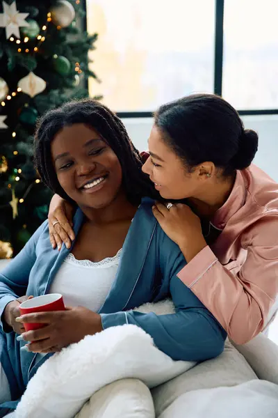 Two women share laughter and warmth while wrapped in blankets on a cold winter day. — Stock Photo