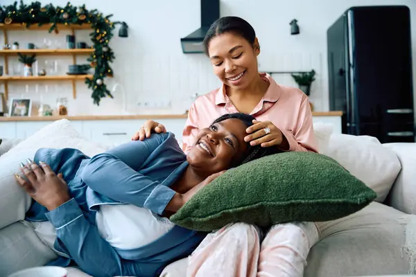 Women share laughter and affection as they enjoy each others company in a warm home. — Stock Photo