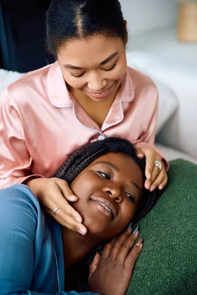 Deux femmes partagent un regard aimant et un toucher doux, enveloppées de chaleur et de joie à la maison. — Photo de stock