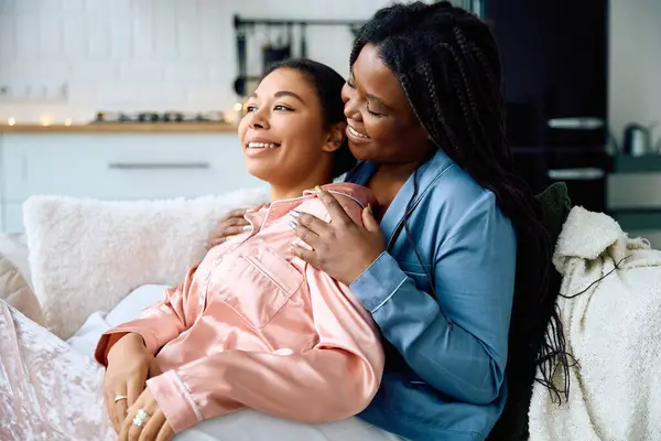 Due donne condividono risate e amore mentre si rilassano insieme su un divano morbido — Foto stock