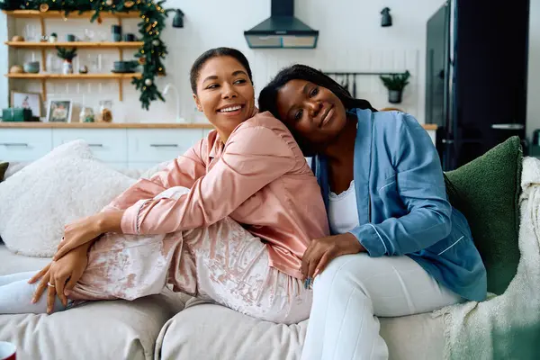 Salón de mujeres en un sofá, disfrutando de la compañía de los demás en un espacio acogedor y estacional. — Stock Photo