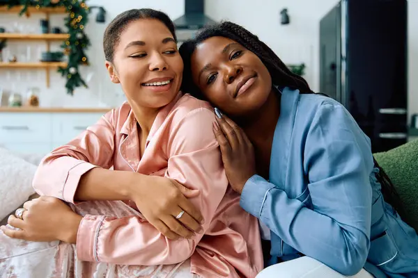 Two joyful women sharing laughter and affection in a warm, inviting home setting filled with love. — Stock Photo