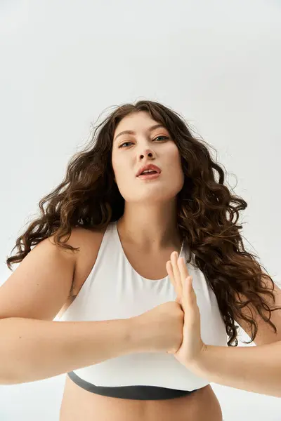 Jeune femme plus taille pose élégamment dans les sous-vêtements à la mode, exsudant la confiance et le style. — Photo de stock