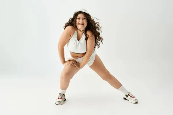 Plus size woman in fashionable underwear expresses joy during a playful modeling session. — Stock Photo