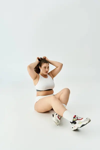Mujer joven abraza su belleza en ropa interior con estilo, irradiando confianza y encanto. - foto de stock