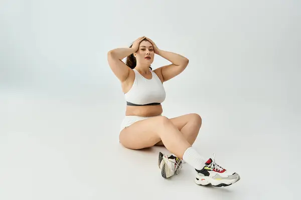 Confident young plus size woman showcases stylish underwear while sitting comfortably. — Stock Photo