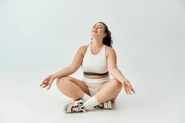 Plus size woman sits cross legged in stylish underwear, radiating tranquility and confidence. — Stock Photo