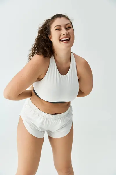 A joyful young plus size woman in stylish underwear beams in a studio setting. — Stock Photo