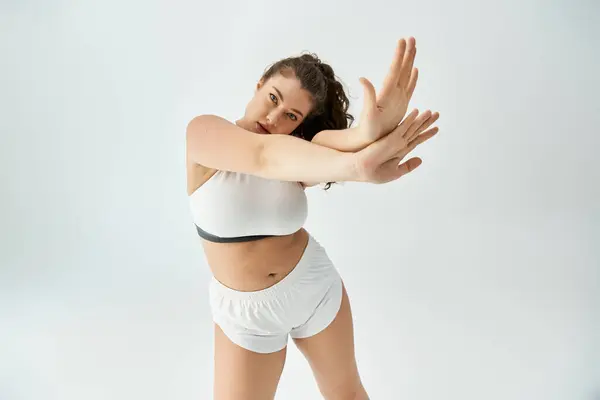 Confident young woman showcases her trendy plus size underwear in a bright, minimalist studio. — Stock Photo