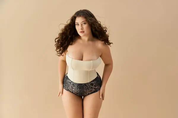 Young woman in stylish underwear exudes confidence while posing against a soft, neutral backdrop. — Stock Photo