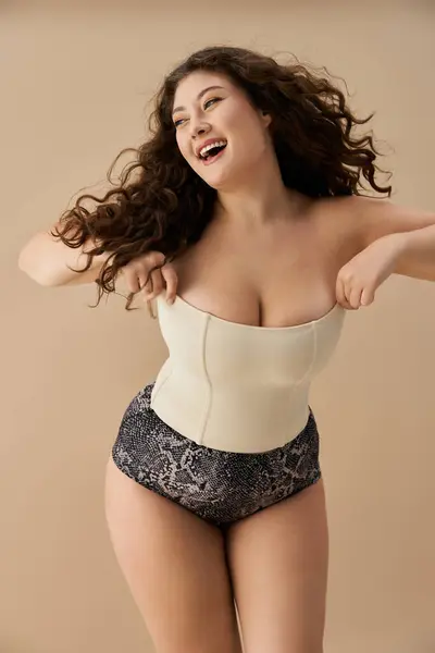 Young woman with a beautiful smile confidently displays fashionable underwear while posing. — Stock Photo