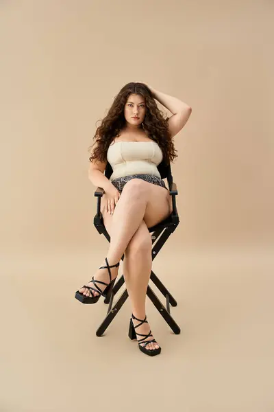 Giovane plus size donna siede elegantemente in biancheria intima elegante, in mostra le tendenze della moda moderna. — Foto stock