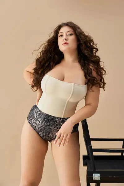 Young plus size woman poses beautifully in trendy underwear against a soft neutral backdrop. — Stock Photo