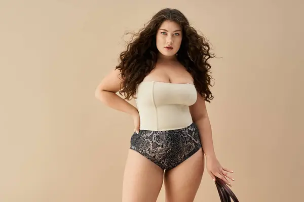 Junge Plus-Size-Frau zeigt ihr Vertrauen in trendige Unterwäsche vor weichem Hintergrund — Stockfoto