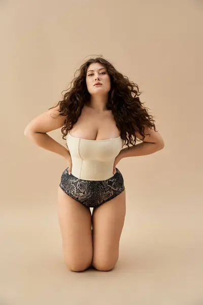 Confident plus size woman poses gracefully in fashionable underwear against a soft backdrop — Stock Photo