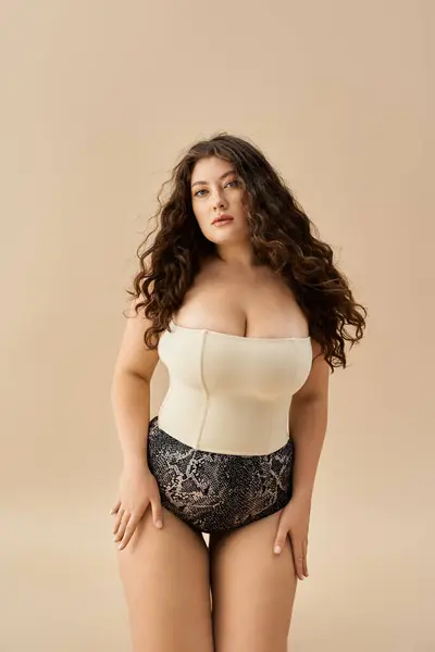 Giovane plus size donna posa con fiducia in biancheria intima elegante evidenziando la sua bellezza e curve. — Foto stock