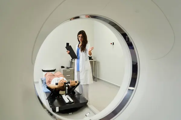 Une femme médecin instruit un patient lors d'une IRM dans un département de radiologie. — Photo de stock