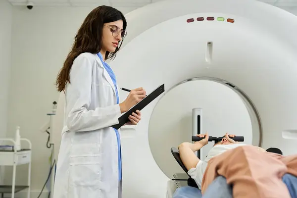 Um médico em um jaleco monitora um paciente submetido a uma ressonância magnética em um quarto de hospital. — Fotografia de Stock
