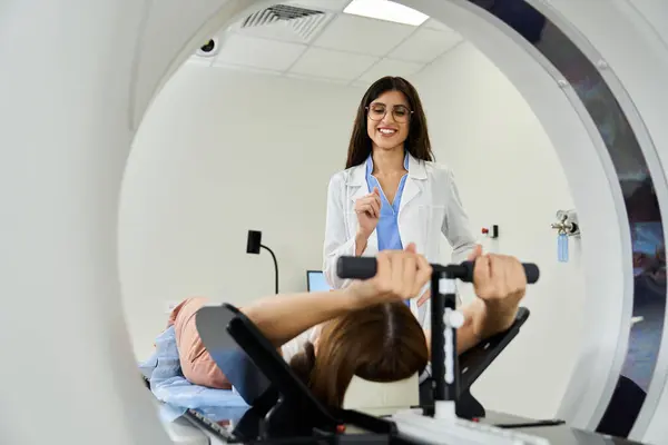 A médica auxilia o paciente quando ele é submetido a uma ressonância magnética em um hospital. — Fotografia de Stock