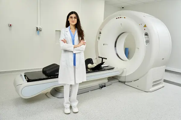 Attractive doctor stands confidently beside advanced MRI equipment, ready to enhance diagnostics. — Stock Photo