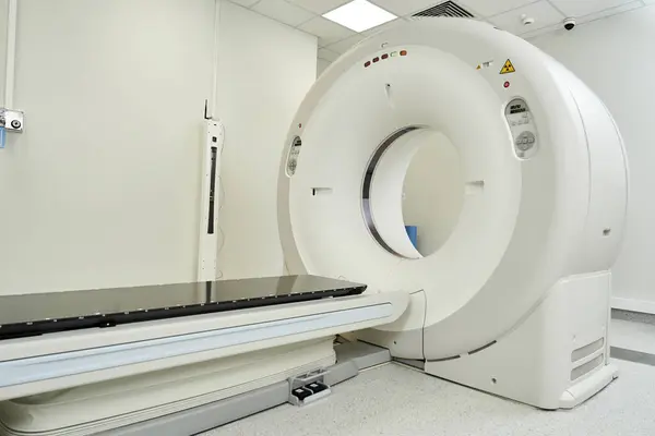 Bright, modern hospital room showing an MRI machine ready for diagnostic testing and patient care. — Stock Photo