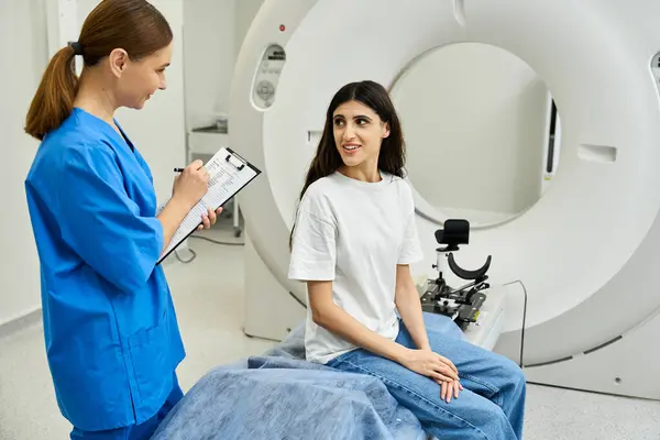 Une femme en blouse de laboratoire discute de la procédure d'IRM avec un patient dans un établissement de santé. — Photo de stock